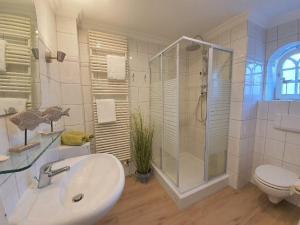 a bathroom with a sink and a shower and a toilet at Hues-Sylt in Morsum