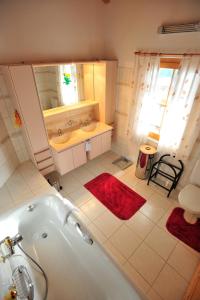 ein Badezimmer mit einer Badewanne und einem Waschbecken in der Unterkunft Bed & Breakfast La Val in Trin