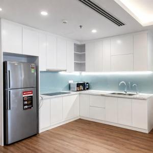 a kitchen with white cabinets and a stainless steel refrigerator at BRG Luxury Apartments in Hai Phong