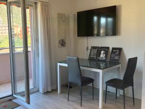 a desk with two chairs and a television on the wall at Lake Agno Apartment in Agno