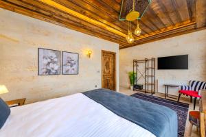 a bedroom with a bed and a flat screen tv at Pegas Goreme in Göreme