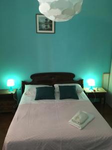 a blue bedroom with a large bed with two lamps at House Steccuto in Florence