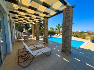 a patio with a chair and a swimming pool at Villa Sea View in Kyrenia