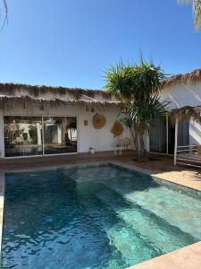 a swimming pool in front of a house at DOMAINE DU DOUAR in Marrakesh