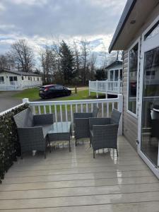 a deck with chairs and tables on a house at Castle Lakes 60 - Wifi Included in Goswick Station