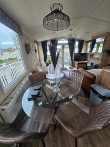 a living room with a glass table and chairs at Castle Lakes 60 - Wifi Included in Goswick Station