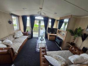 a living room with two couches and a tv at Castle Lakes 60 - Wifi Included in Goswick Station