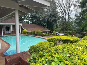 a swimming pool in front of a house at Comrades Oasis Guest House in Pietermaritzburg