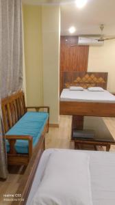 a room with two beds and a chair in it at M D Guest House in Guwahati