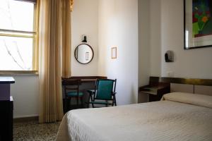 a bedroom with a bed and a desk and a table at Hotel Napoleon Rimini - City & Station in Rimini
