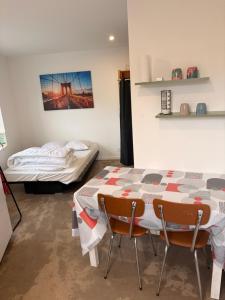 a room with a table and chairs and a bed at Studio charleureux et cosy in Sceaux-dʼanjou