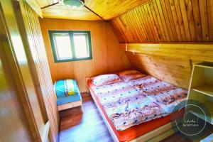 a bedroom with a bed in a wooden cabin at Chata MIMONKA in Dedinky