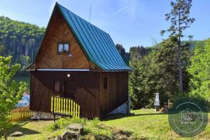 a small wooden house with a blue roof at Chata MIMONKA in Dedinky