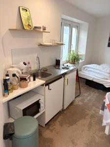 a small kitchen with a sink and a bed at Studio charleureux et cosy in Sceaux-dʼanjou