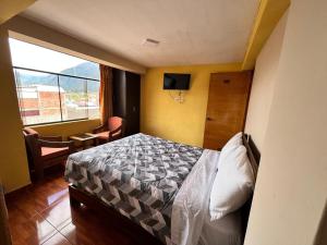 a small bedroom with a bed and a window at Refugio del Valle del Sol in Urubamba