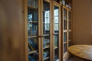 a wooden cabinet with glass doors with books at Doppelzimmer mit Bad in Möllenhagen