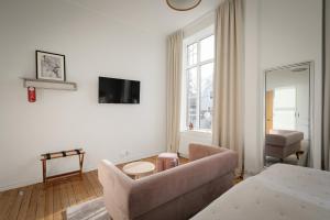a living room with a couch and a tv on a wall at L Boutique Hotel in Lysekil