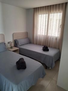 two beds with hats on them in a room at Casa la Pluma Torrevieja in Torrevieja