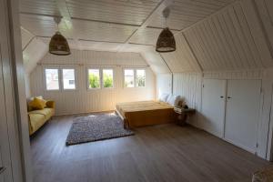 a bedroom with a bed and a couch in a room at Casa Feia Hostel in Costa da Caparica