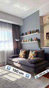 a living room with a couch and a table at Divine Studio Fermei 62 in Popeşti-Leordeni