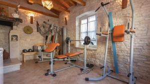 a gym with exercise equipment in a stone wall at Villa Mela by Villas Guide in Barban