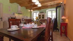 a dining room with a wooden table and a kitchen at Villa Mela by Villas Guide in Barban
