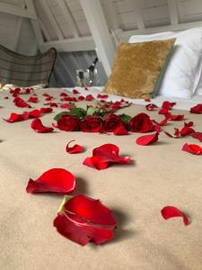 a bunch of red roses on a bed at Poorter Boutique Hotel Brielle in Brielle