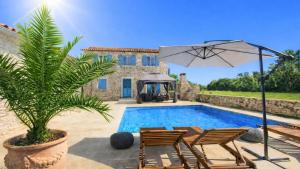a villa with a swimming pool with chairs and an umbrella at Villa Mela by Villas Guide in Barban