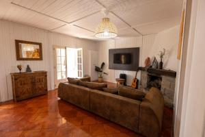 a living room with a couch and a fireplace at Casa Feia Hostel in Costa da Caparica