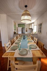 a long wooden table with chairs and a large room at Casa Feia Hostel in Costa da Caparica