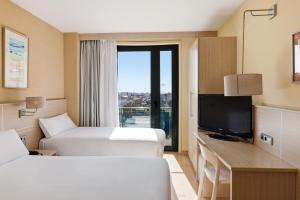 a hotel room with two beds and a television at B&B HOTEL Tarragona Valls in Valls