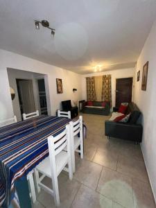 a living room with a table and a couch at Departamento duplex Pinamar in Pinamar