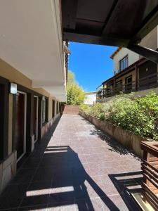 a hallway of a building with a brick sidewalk at Departamento duplex Pinamar in Pinamar