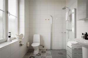 a white bathroom with a toilet and a sink at L Boutique Hotel in Lysekil +22 photos