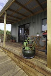 a wooden deck with a large pot on it at Leven Studio - StayTiny at Ulverstone in Ulverstone