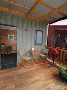 a patio with chairs and a table on a deck at Leven Studio - StayTiny at Ulverstone in Ulverstone +1 photo