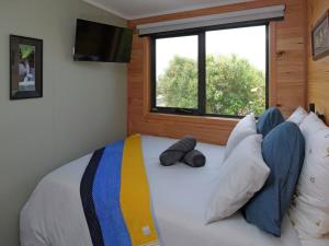 a bedroom with a bed with pillows and a window at Leven Studio - StayTiny at Ulverstone in Ulverstone