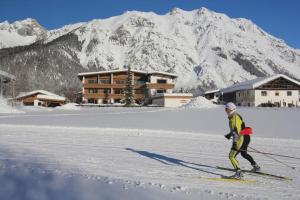 a man is skiing in the snow in front of a lodge at Chalet Cristall Superior Appartement 4 in Leutasch