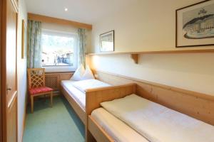 a small room with two beds and a window at Chalet Cristall Superior Appartement 4 in Leutasch