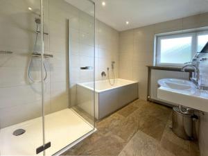 a bathroom with a shower and a tub and a sink at Chalet Cristall Superior Appartement 4 in Leutasch +16 photos