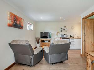 two chairs in a living room with a kitchen at 1 Bed in Norwich oc-46293 in Brundall