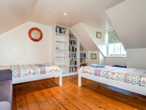 a attic bedroom with two beds and a book shelf at 3 Bed in Whitstable oc-wcc07 in Whitstable