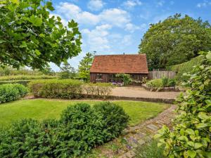a garden with a small house in the background at 1 Bed in Battle oc-94675 in Warbleton