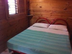 a bed in a room with a wooden wall at Chalet Pineta Mare in Foce Varano