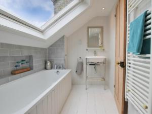 a bathroom with a large bath tub and a skylight at 3 Bed in Whitstable oc-wcc17 in Whitstable +13 photos