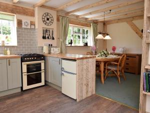 a kitchen with a table and a stove top oven at 1 Bed in Etchingham oc-62641 in Burwash