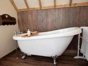 a white bath tub in a bathroom with wooden walls at 1 Bed in Etchingham oc-62641 in Burwash +10 photos