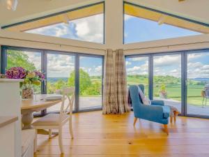a living room with a table and chairs and large windows at 2 Bed in Montgomery oc-83243 in Llandyssil