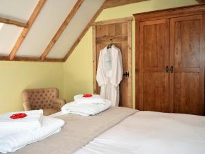 a bedroom with two beds and a robe hanging on a door at 1 Bed in Etchingham oc-62641 in Burwash