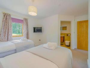 a white bedroom with two beds and a window at 2 Bed in Montgomery oc-83243 in Llandyssil